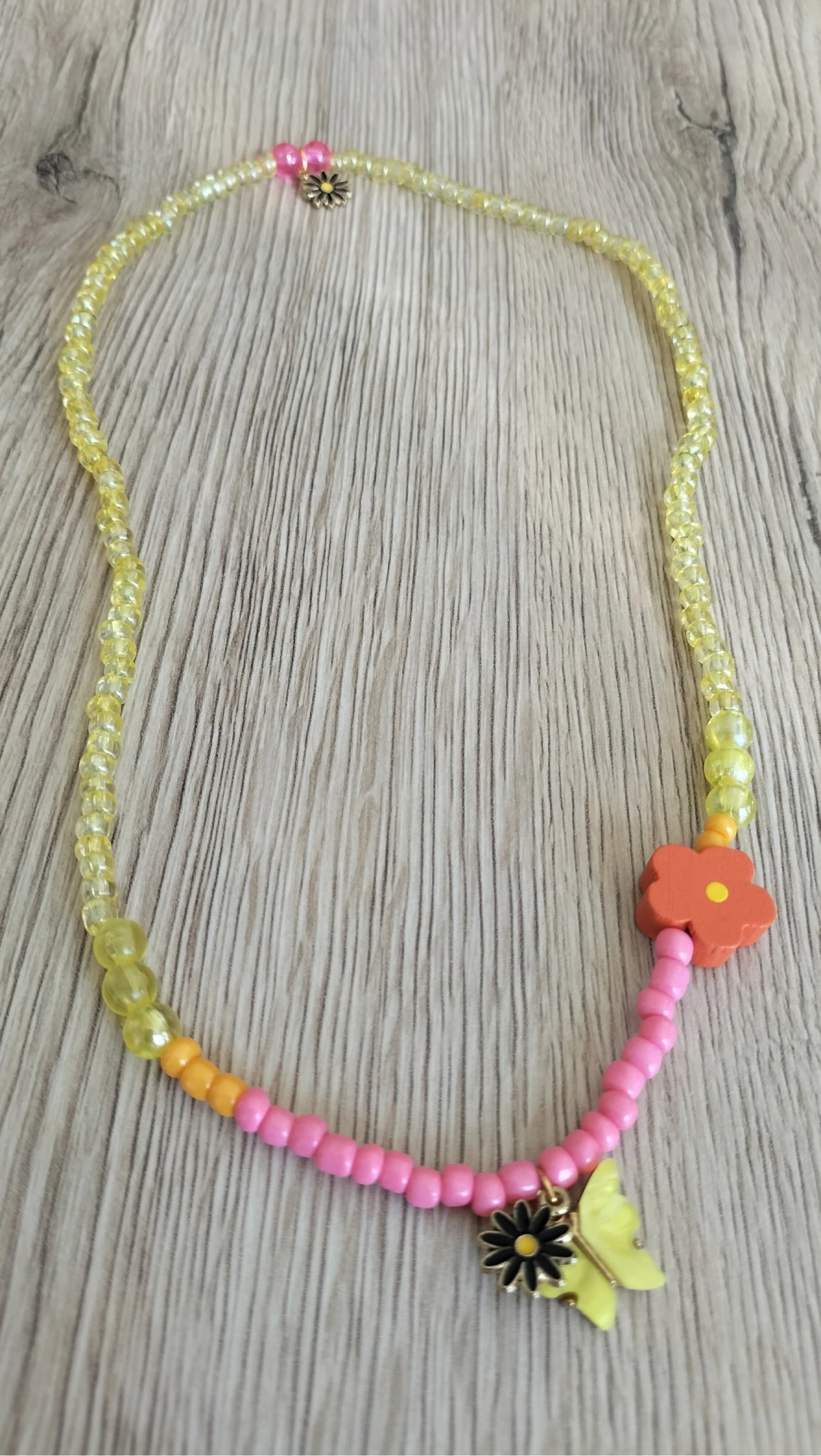 Collier à perles avec charm papillon et fleur 